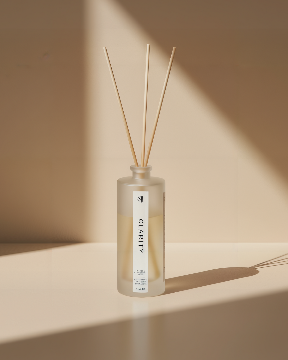 Reed diffuser bottle labeled 'Clarity' on a beige background